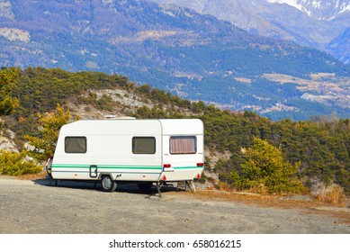 Caravan With A Bike Parked On A Mountaintop With A View On The French Alps Near Lake Lac De Serre-Poncon On A Bright Sunny Day