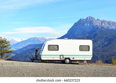 Caravan With A Bike Parked On A Mountaintop With A View On The French Alps Near Lake Lac De Serre-Poncon On A Bright Sunny Day