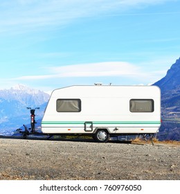 Caravan With A Bike Parked On A Mountaintop With A View On The French Alps Near Lake Lac De Serre-Poncon On A Bright Sunny Day