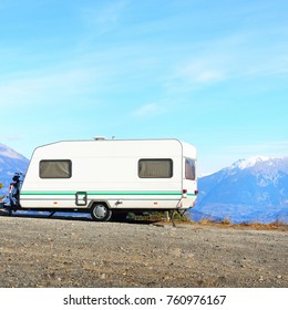 Caravan With A Bike Parked On A Mountaintop With A View On The French Alps Near Lake Lac De Serre-Poncon On A Bright Sunny Day