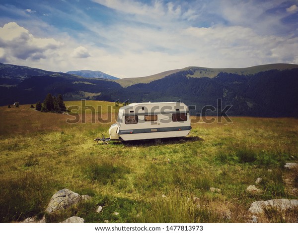 caravan camped in the mountains. Beautiful camper\
van under a gorgeous sky. Abandoned caravan on a mountain peak.\
Explore. In:  Romania , Transalpina , Carpathians, Europe. Date:\
August 13, 2019