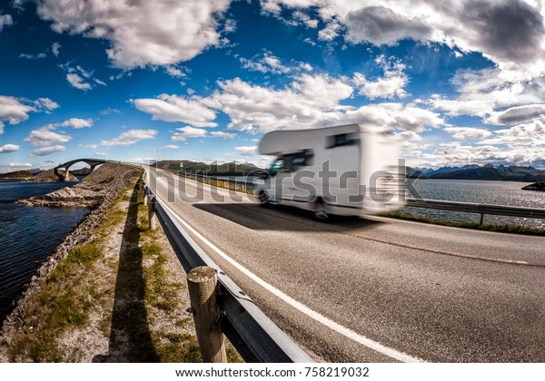 Caravan car RV\
travels on the highway Norway. Atlantic Ocean Road or the Atlantic\
Road (Atlanterhavsveien) been awarded the title as (Norwegian\
Construction of the\
Century).