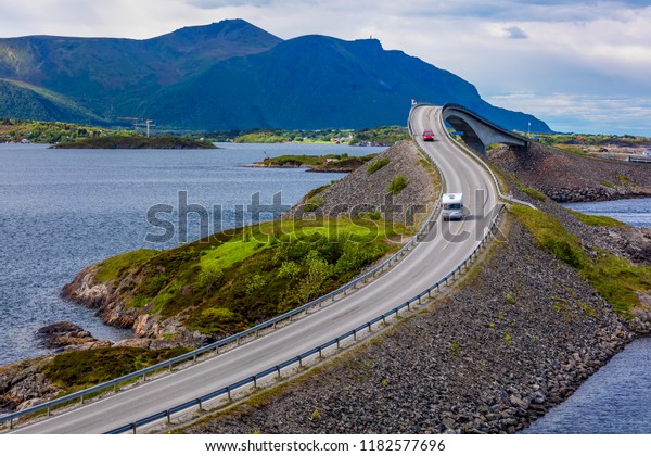 Caravan car travels on the\
highway. Atlantic Ocean Road or the Atlantic Road\
(Atlanterhavsveien) been awarded the title as (Norwegian\
Construction of the\
Century).