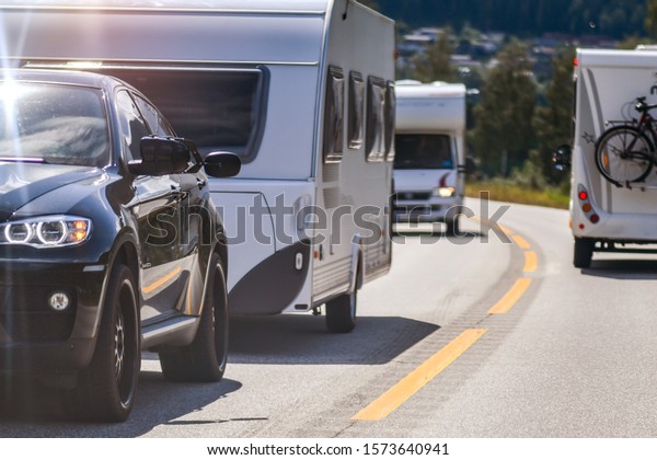 Caravan cars travel on the\
highway. Caravans in high speed. Norway country. Atlantic Ocean\
road holiday.