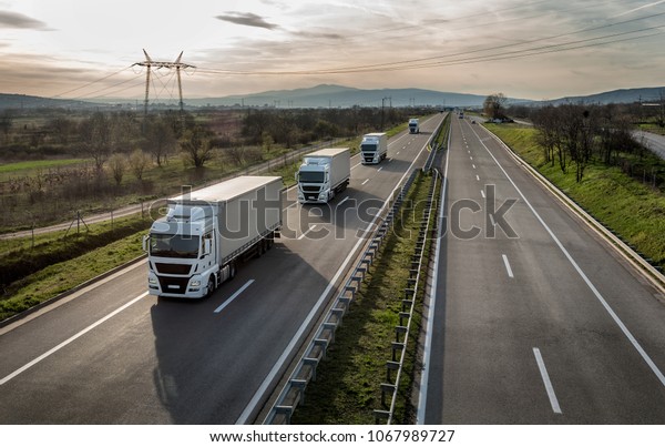 Caravan\
or convoy of trucks in line on a country\
highway