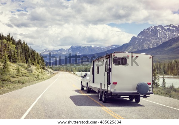 Caravan or recreational vehicle motor home trailer\
on a mountain road in\
Canada