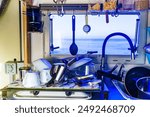 Caravan rv inside, dishwashing in kitchen. Many clean dishes on dish drying mat after washing up. Longing for an rv dishwasher. Holidays, travel and camping. Van life lifestyle.