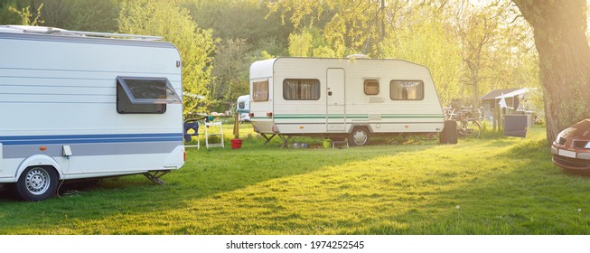 Caravan Trailer And A Car Parked On A Green Lawn In A Camping Site. Idyllic Spring Landscape. Holland. RV, Transportation, Road Trip, Vacations, Ecotourism, Travel, Lifestyle, Recreation