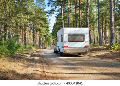 Caravan Trailer On A Forest Road, On A Sunny Spring Day