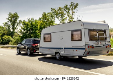 Caravan trailer on a freeway road. Family vacation travel, holiday trip in motorhome RV.