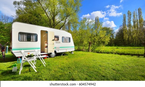 Caravan trailer on a green lawn, on a sunny spring day