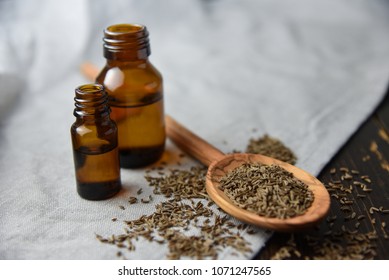 Caraway Oil And Seeds On Wooden Spoon And Essential Oil