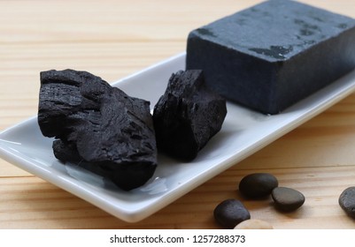 Carbon And Bamboo Charcoal Soap On Wood Background