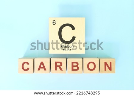 Carbon chemical element symbol with atomic mass and atomic number in wooden blocks flat lay composition. Chemistry and Science concept.