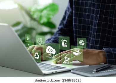 carbon credit concept. Man using a laptop to trade carbon credit on a virtual screen. carbon etf to invest in sustainable business. Carbon neutral balancing CO2 emission offset.Net zero emission.Esg