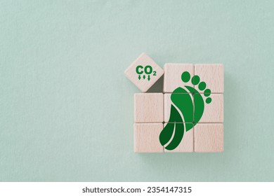 Carbon ecological footprint symbols with green leaves, reduce co2 on wooden cube blocks. eco friendly, zero emission concept.  Sustainable development. Environmental and climate change concept