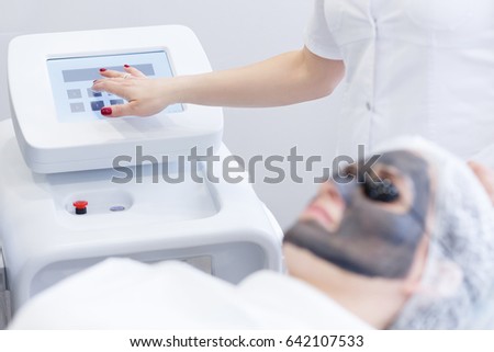 Carbon face peeling procedure. Laser pulses clean skin of the face. Hardware cosmetology treatment. Process of photothermolysis, warming the skin, laser carbon peeling. Facial skin rejuvenation.