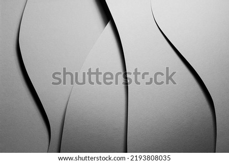 Carbon grey abstract geometric background with soar vertical curved waves pattern in hard light with black shadows as monochrome stylish backdrop in elegant simple modern minimal style, top view.