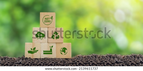 Carbon neutral and net zero\
concept natural environment Climate-neutral long-term strategy\
greenhouse gas emissions targets Wooden block with green net center\
icon