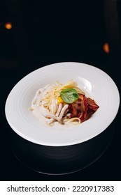 Carbonara Pasta With Bacon And Cream Sauce. Decorated With Egg Yolk And Basil.