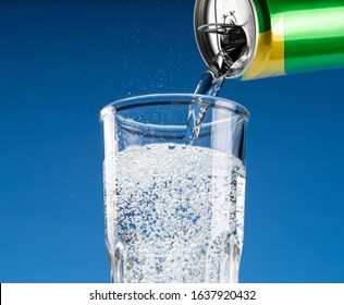 Carbonated Drink Pours From An Aluminum Can Into A Glass