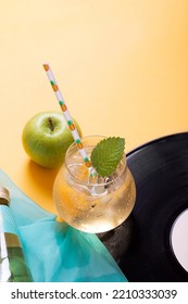 Carbonated Lemonade In A Glass And A Green Apple. Yellow Background.