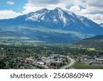 Carbondale, Colorado showcases a stunning landscape of snow-capped Mt Sopris and vibrant greenery under a bright sky.