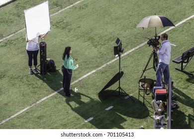 CARBONDALE, IL/USA - AUGUST 21, 2017: Two Technicians And A Cameraman Check Pre-event Lighting Conditions In Saluki Stadium At Southern Illinois University Before Today's Coast-to-coast Solar Eclipse.