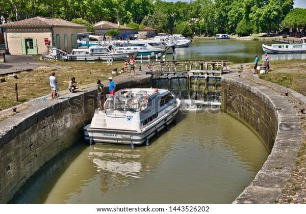Carcassonne, Aude,France. 07/04/19. Holiday makers\
navigate a lock on the Canal du Midi in Carcassonne city centre.\
Water flows into the lock through sluice gates. Canal boats moored\
along the bank.