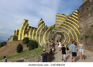 CARCASSONNE, FRANCE - 07-28-2018: Installation art by italian artist Felice Varini in the Castle of Carcassonne. Fortified medieval city, UNESCO. Yellow circles.