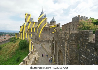 Carcassonne, France - June 15th, 2018: Carcassonne with temporary yellow circles on the outside walls, artwork on the occasion of 20 years Unesco heritage in 2018