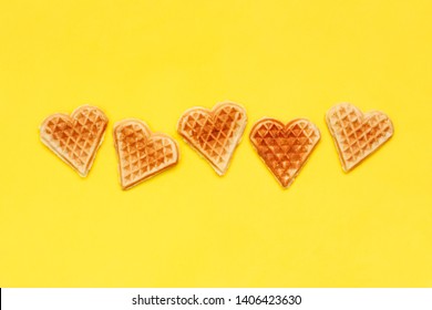Card with crisp biscuit cookies waffles on yellow background. Shape of heart. For holidays Valentine's Day, Women's Day, Mother's Day. Row of homemade sweets. love food concept