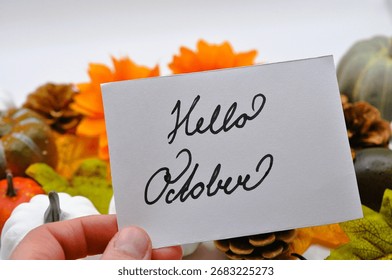 card with hello october write between leaves, sunflowers and pumpkins 