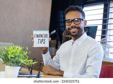 Card with HELPFUL TIPS text in notebook of businessman in hand. Investment and decisions business concept.