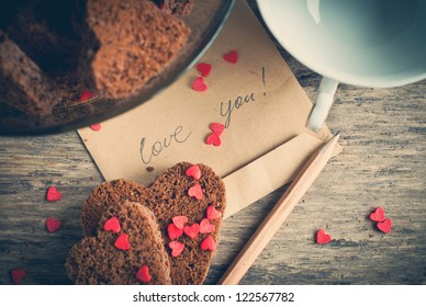 Card with Message Love You on the Letter and Chocolate Cookies Shape of Heart at Valentine's Day