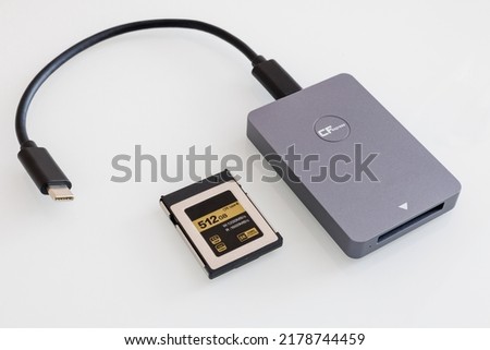 card reader for cfexpress memory cards on a white background. Next to a 512 GB memory card