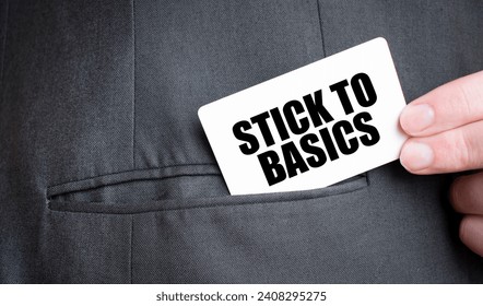Card with STICK TO BASICS text in pocket of businessman suit. Investment and decisions business concept.