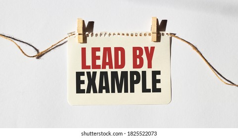 Card with text LEAD BY EXAMPLE. Diagram and white background