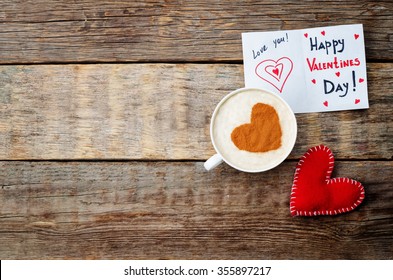 card for Valentines day, red toy heart and a cup of coffee on a dark wood background. toning. selective Focus