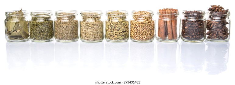 Cardamom, star anise, cinnamon, clove, coriander seed spices and dried bay leaves, parsley, thyme, rosemary herbs in mason jars over white background - Powered by Shutterstock