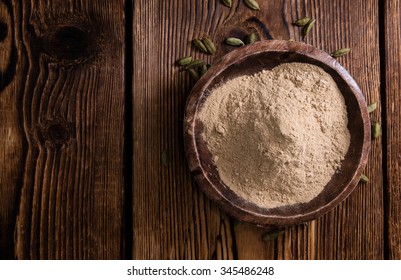 Cardamon Powder on wooden background (detailed close-up shot)