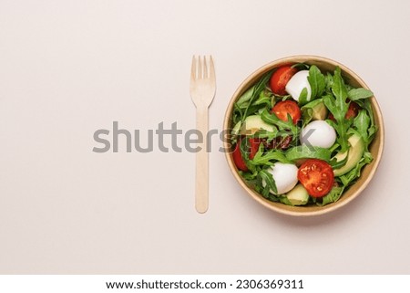 Cardboard bowl container with fresh caprese salad. Food delivery, zero waste, recycling packaging, eco friendly concept