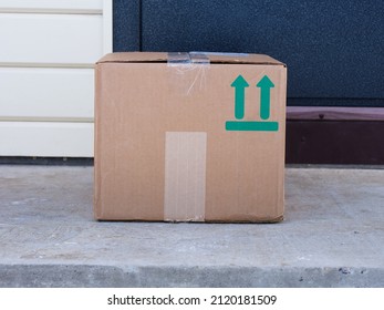 A Cardboard Box Delivered To The House Door. Sign This Way Up Printed On Box.