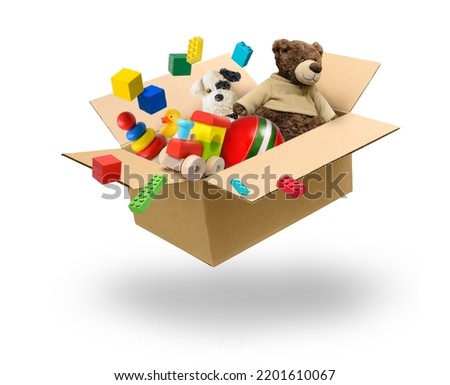 Cardboard box with many toys flying over white background