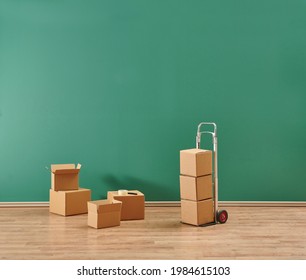 Cardboard Box Moving Style In The Room With Trolley And Hand Truck.