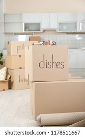 Cardboard boxes and adhesive tape dispenser in kitchen. Moving day - Shutterstock ID 1178511667
