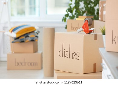 Cardboard boxes and adhesive tape dispenser indoors. Space for text - Shutterstock ID 1197623611