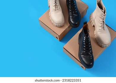 Cardboard boxes with female boots on blue background