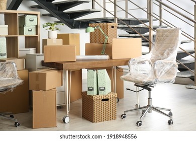 Cardboard boxes and furniture near stairs in office. Moving day - Powered by Shutterstock