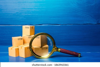 Cardboard boxes and magnifying glass. Concept of searching for goods and components. Procurement audit. Quality control. Supply and demand, distribution of products on the market. Cargo tracking